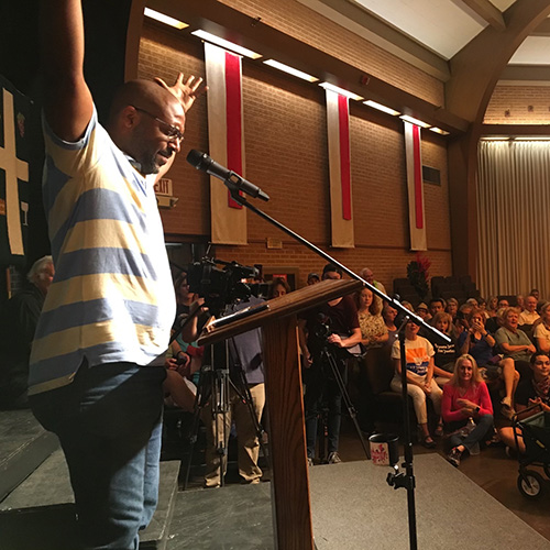 Brent Whiting hosting and raising his arms at a Lights for Liberty Rally